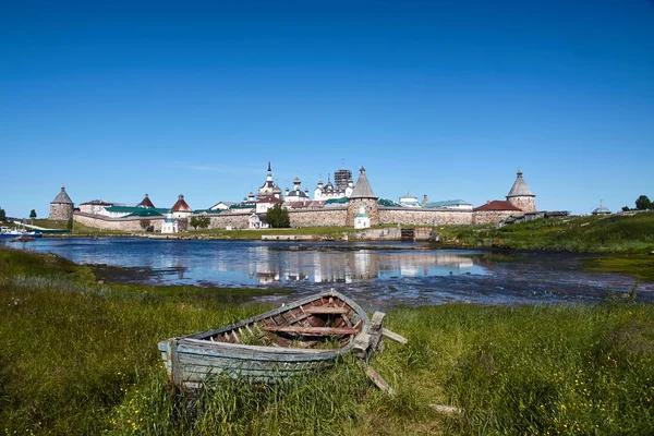 Vecchia barca di legno di fronte all'antico monastero Solovetsky Foto Stock Royalty Free