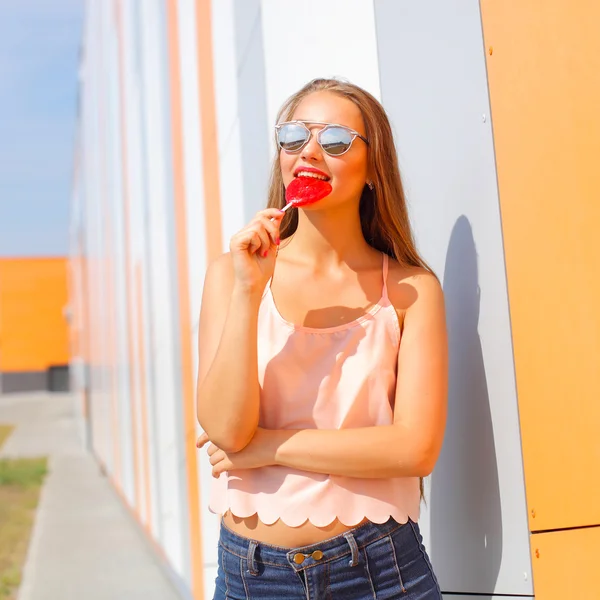 Glad flicka i solglasögon med godis — Stockfoto