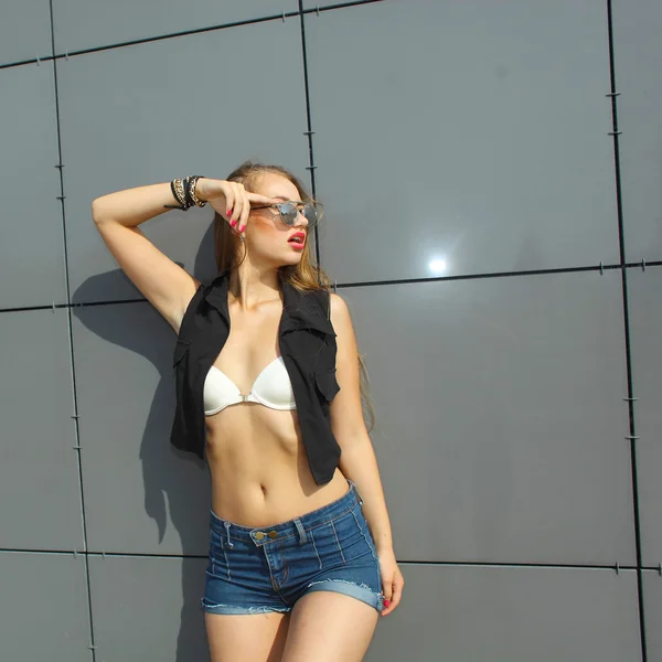 Fashionabla flicka står nära vägg — Stockfoto
