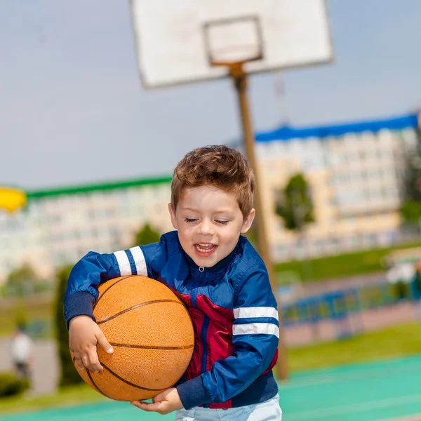Menino feliz jogando basquete — Fotografia de Stock