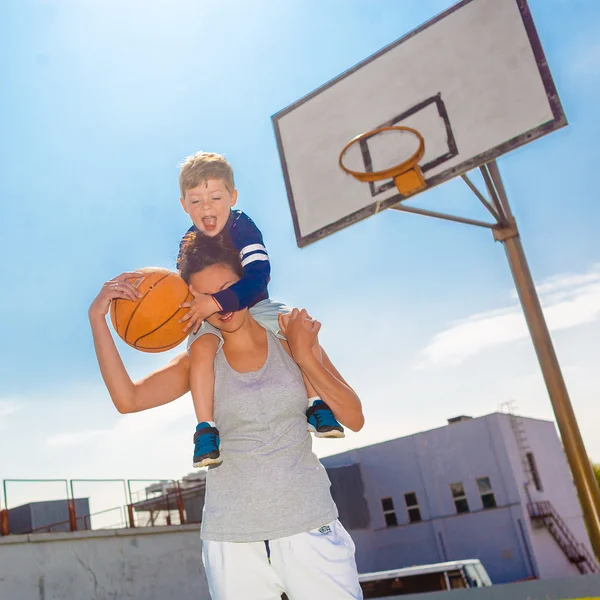 Мама и маленький сын играют в баскетбол — стоковое фото