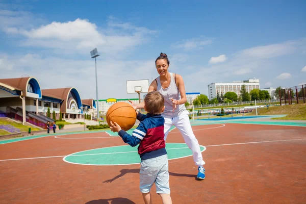 Anne ve küçük oğlu basketbol oynarken Stok Fotoğraf
