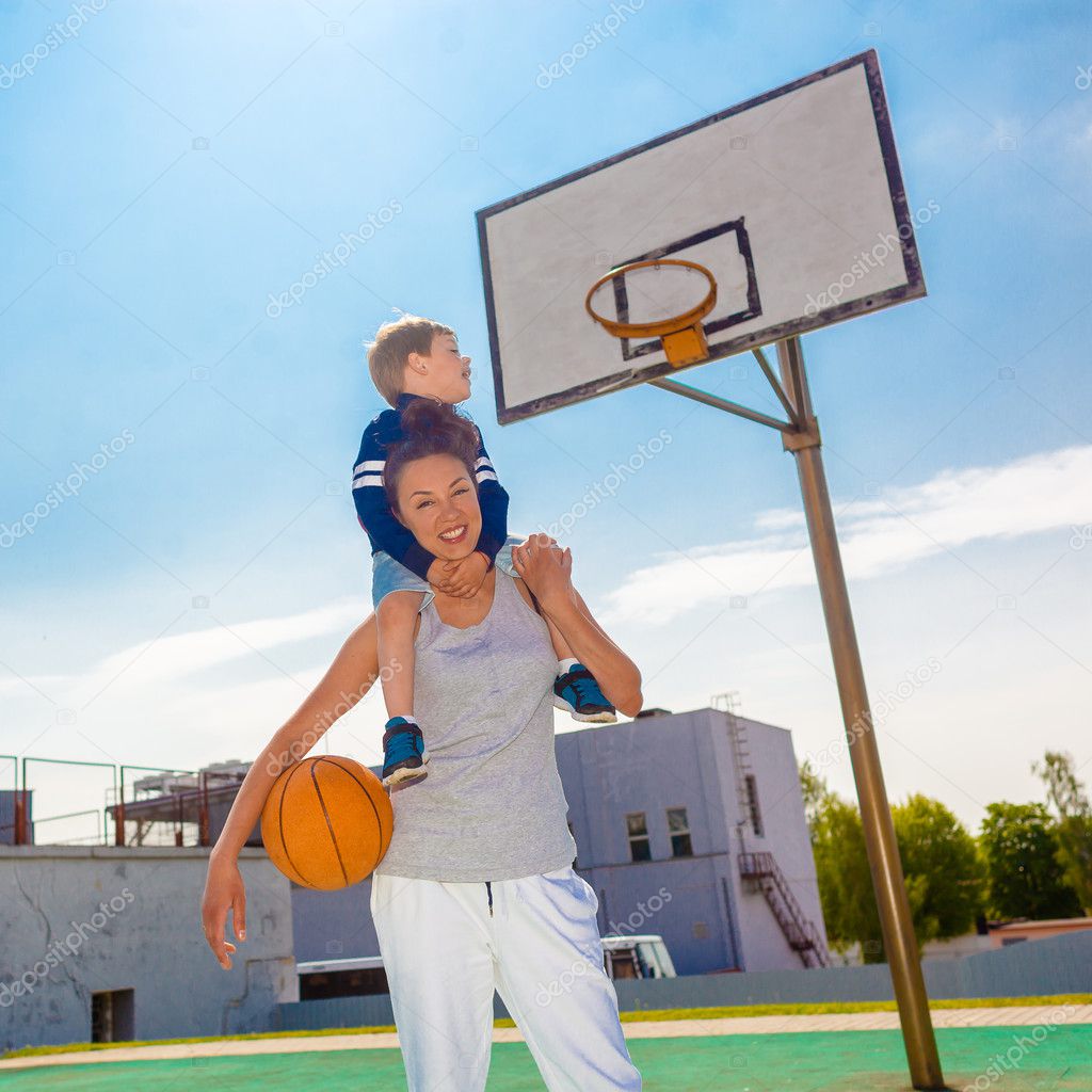 Mom and little son playing basketball 