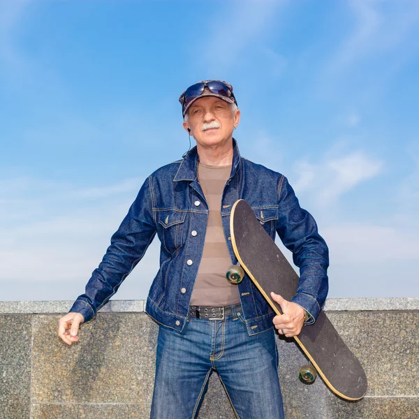 Senior man standing with skate — Stock Photo, Image