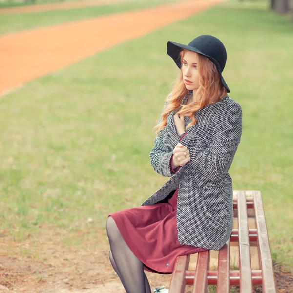 Расстроенная красивая девушка сидит в парке — стоковое фото