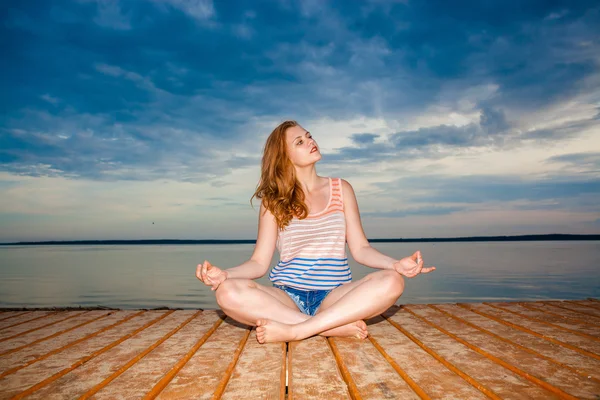 Dívka meditaci na dřevěném molu — Stock fotografie