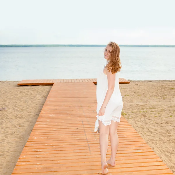 Дівчина стоїть у білій сукні — стокове фото
