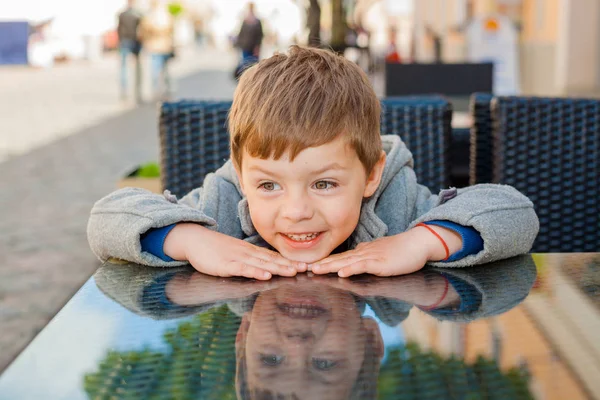 Emotionaler Junge an einem Tisch in einem Café — Stockfoto