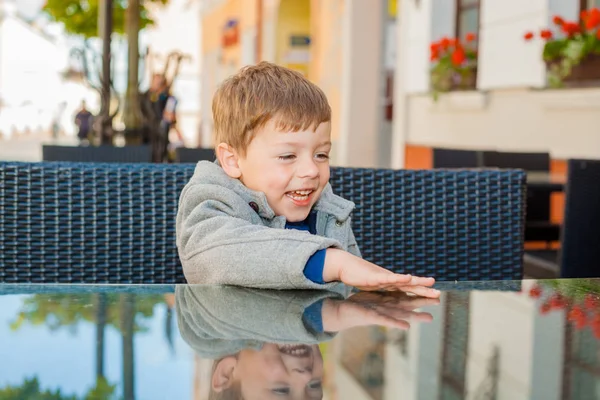 Emotionele jongen aan een tafel in een café — Stockfoto