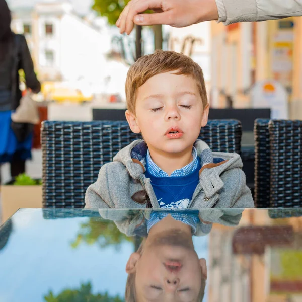 Känslomässiga pojke vid ett bord på ett café — Stockfoto