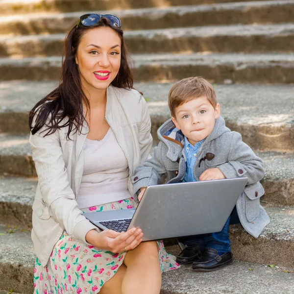 Maman avec fils et ordinateur portable dans les escaliers du parc — Photo
