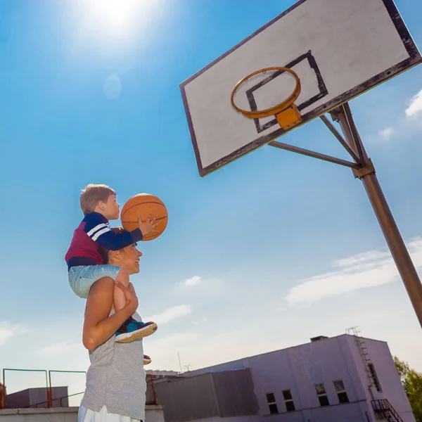 Mom and little boy son playing basketball