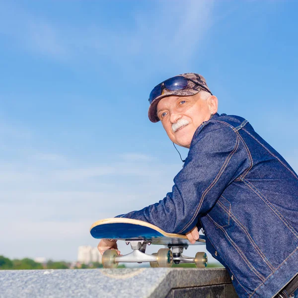 Vieil homme énergique qui aime faire du skateboard — Photo