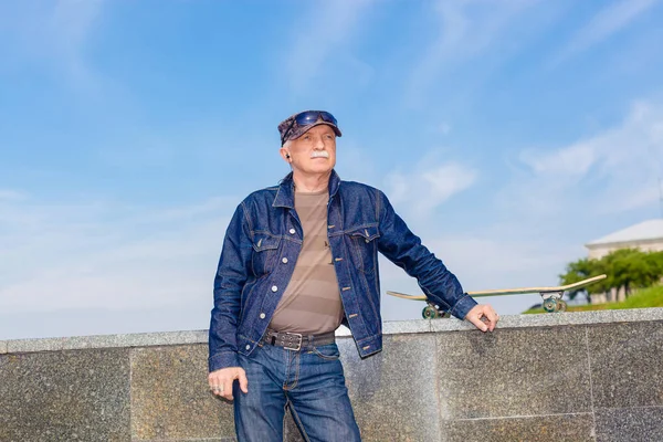 Energisk senior mannen njuter rida en skateboard — Stockfoto