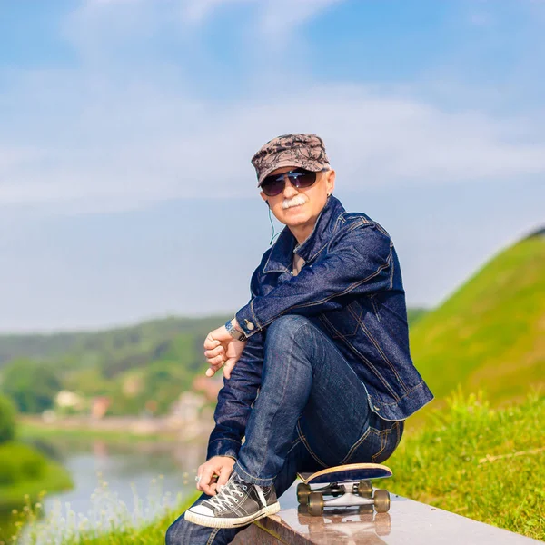 Sognante hipster felice uomo anziano in occhiali da sole su sfondo cielo blu — Foto Stock