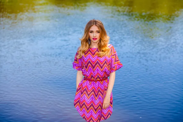 Schöne Mädchen in einem rosa Kleid am Strand — Stockfoto