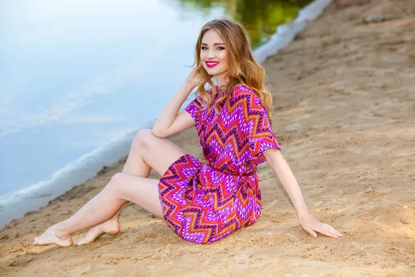 Bella ragazza in un abito rosa sulla spiaggia — Foto Stock