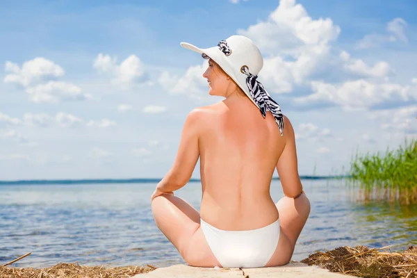 Schöne Rückseite des Models im Bikini im Sitzen. — Stockfoto