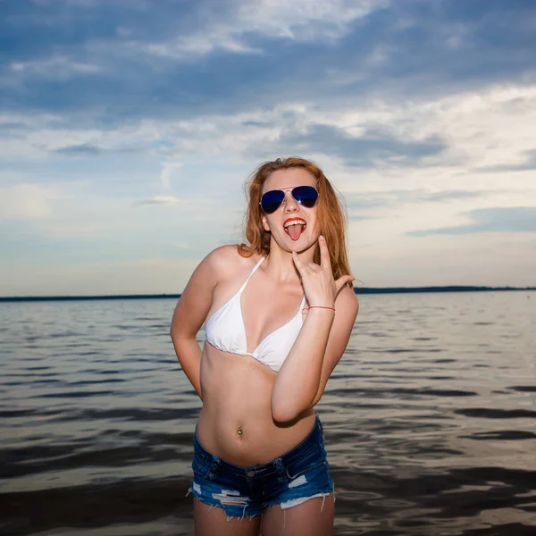 Elegante menina loira hipster na moda no fundo do mar . — Fotografia de Stock