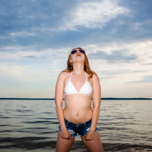 Stijlvolle modieus blond meisje hipster op zee achtergrond. — Stockfoto