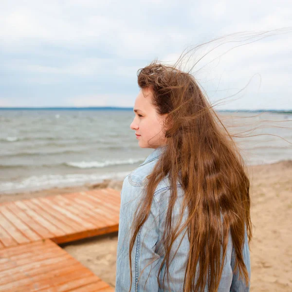 Hermosa adolescente chica en un ventoso otoño playa . —  Fotos de Stock