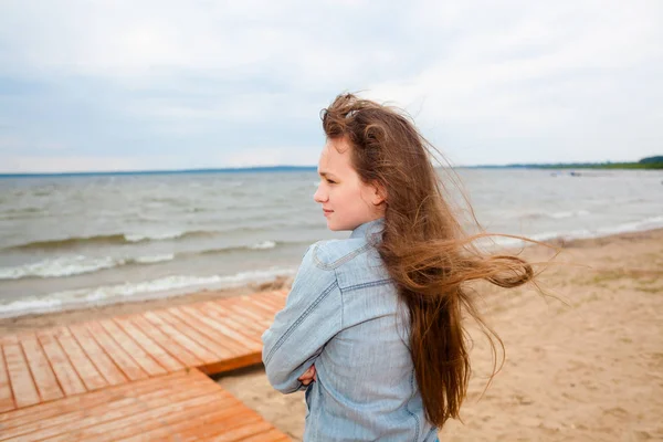 Güzel genç kız rüzgarlı bir sonbahar plajda. — Stok fotoğraf