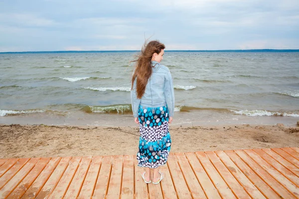 Красивая девочка-подросток на ветреном осеннем пляже . — стоковое фото