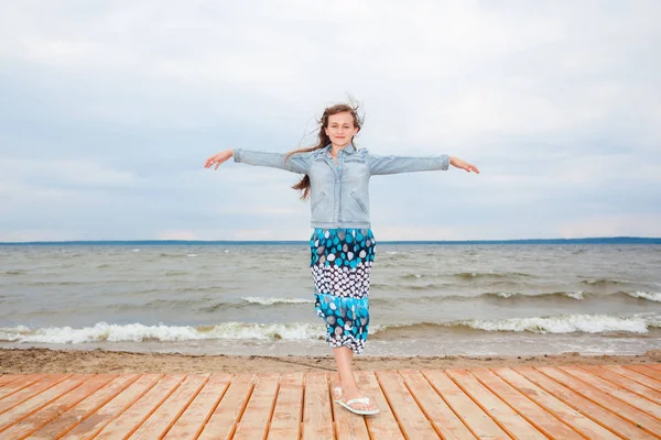 güzel genç kız rüzgarlı bir sonbahar plajda.