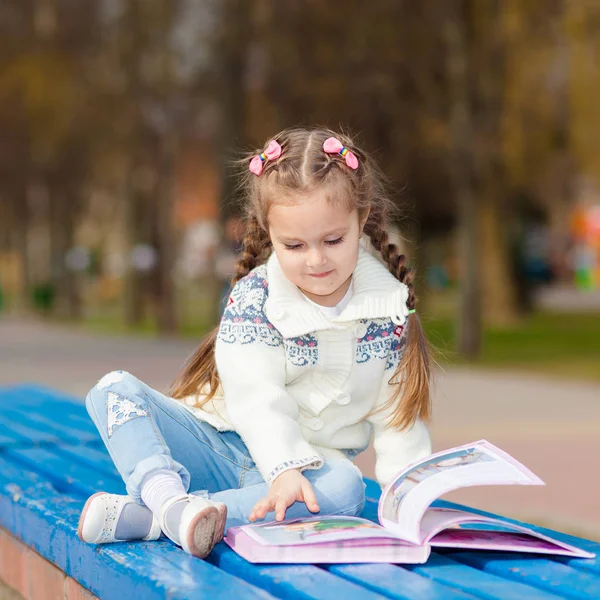 Adorable cute little girl reading book. Adorable little girl reading book in the garden - outdoor — Stock Photo, Image