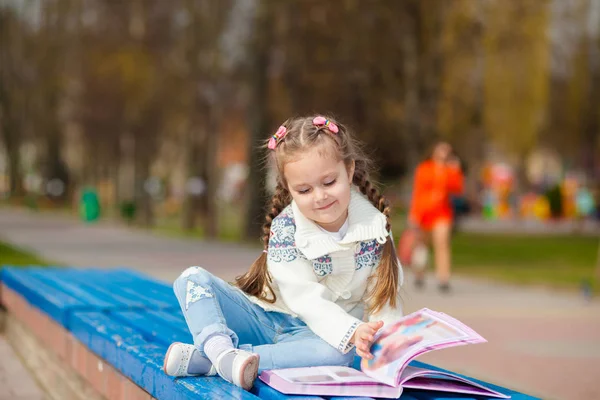 Adorabile carino libro di lettura bambina. Adorabile libro di lettura bambina in giardino - outdoor — Foto Stock