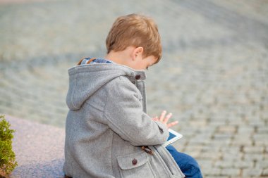 Küçük çocuk bir tablet açık havada kullanır