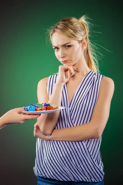 Vrouw twijfels eten snoep of niet — Stockfoto
