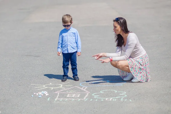 Anne ve küçük oğlu yolda boya kalemi ile boyama. — Stok fotoğraf