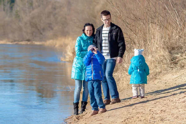 Aantrekkelijke jonge gezin samen op zoek via een spyglass — Stockfoto