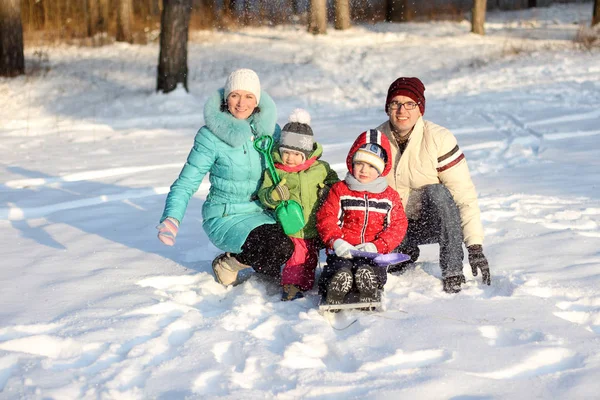 Family of four has fun in the snow in winter — Stock Photo, Image
