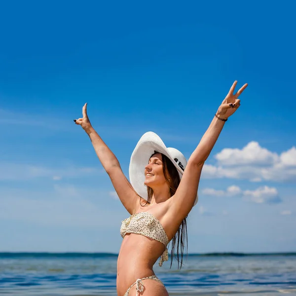 Wet amazing woman in bikini. beautiful girl in a bikini in water. Fitness model posing on the shore