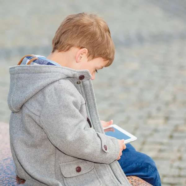 Petit garçon utilise une tablette à l'extérieur — Photo