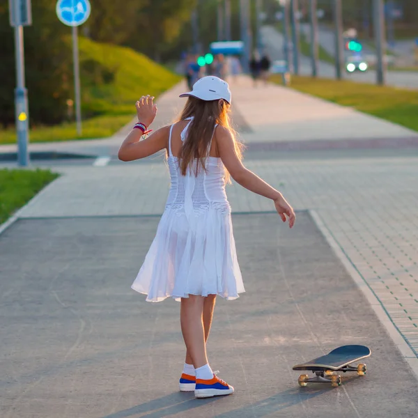 Tienermeisje rijden skateboard op de straat van de avond — Stockfoto