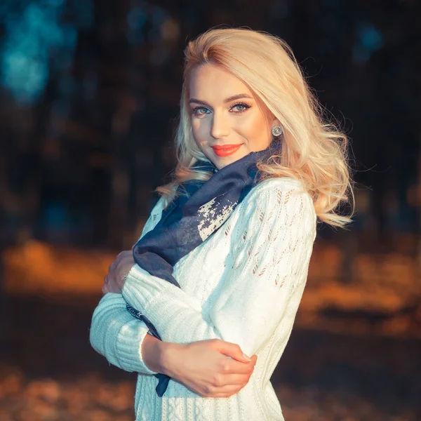 Linda menina loira em uma camisola branca congelando no parque — Fotografia de Stock