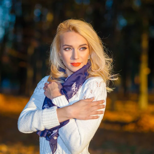 Belle fille blonde dans un pull blanc congélation dans le parc — Photo