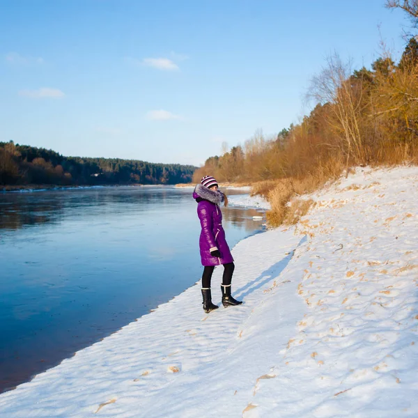 Kışın donmuş nehir kıyısında yürüyen bir genç kız — Stok fotoğraf