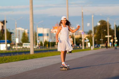 genç kız akşam sokakta kaykay tesisi
