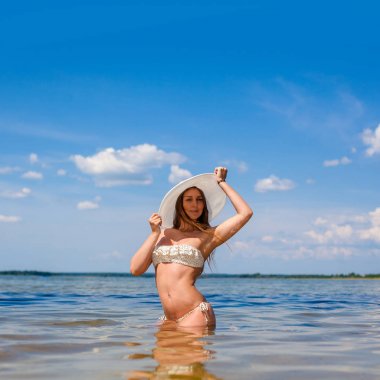 Bikinili ıslak harika bir kadın. Suda bikinili güzel bir kız. Sahilde poz veren fitness modeli