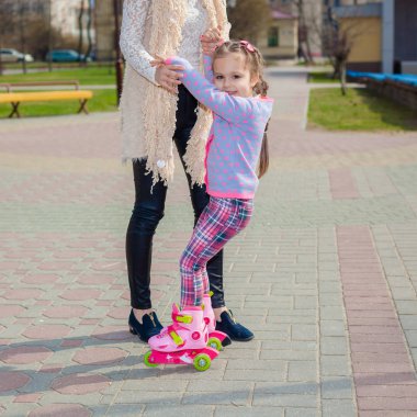 Anne ve kızı tekerlekli paten üzerinde binmek