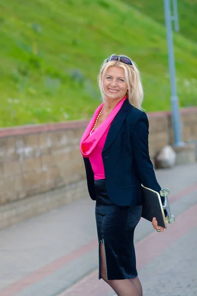 Senior zakenvrouw plezier op een skateboard buitenshuis — Stockfoto