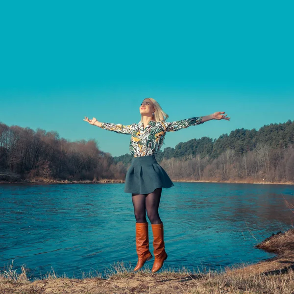 Mutlu genç kadın üzerinde mavi gökyüzü atlama — Stok fotoğraf
