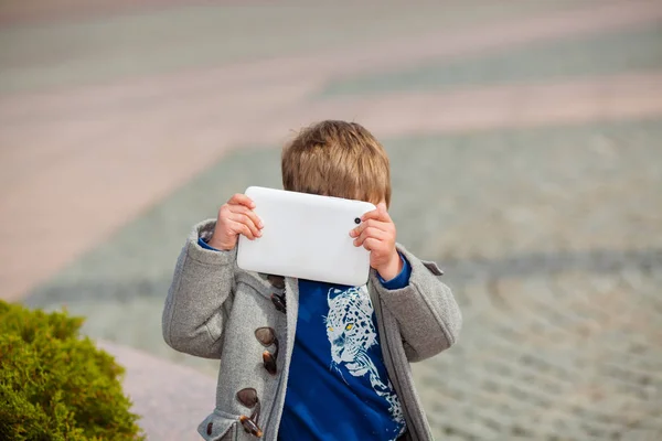 Jongetje maakt gebruik van een tablet buitenshuis — Stockfoto