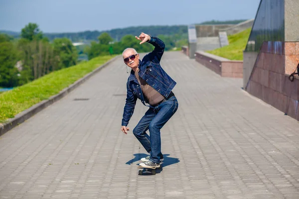 Vieil homme énergique qui aime faire du skateboard — Photo