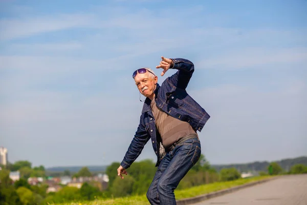 Energetic senior man enjoying riding a skateboard — Stock Photo, Image