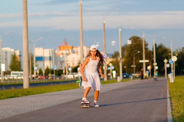 十几岁的女孩在晚上街上骑滑板 — 图库照片